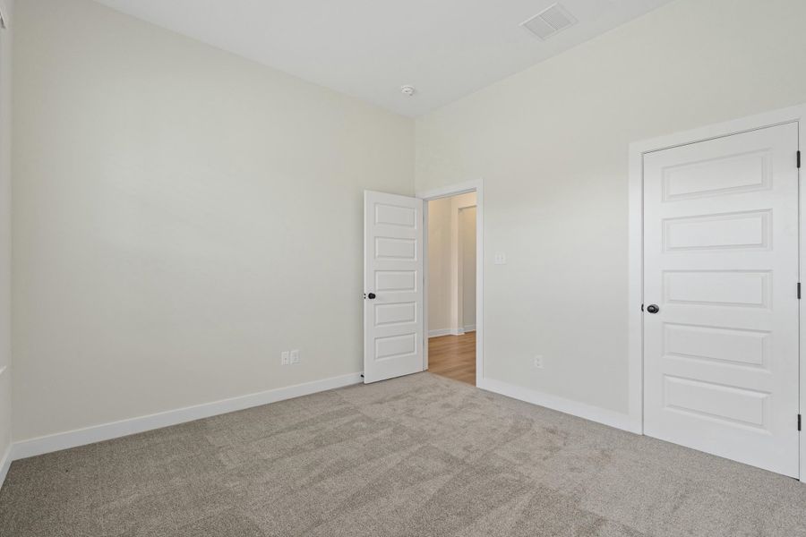 Carpeted interior space featuring light-toned walls and white trim Carpeted interior space featuring light-toned walls and white trim