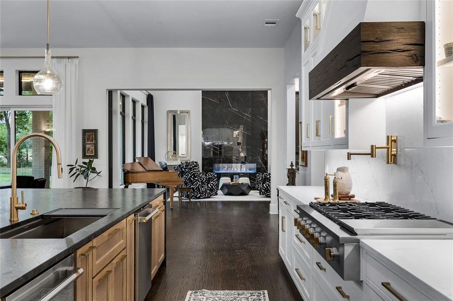 Kitchen featuring pendant lighting, white cabinets, sink, decorative backsplash, and stainless steel appliances