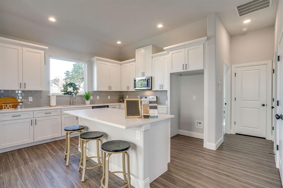 Kitchen featuring white cabinetry, dark wood-style flooring, tasteful backsplash, and recessed lighting