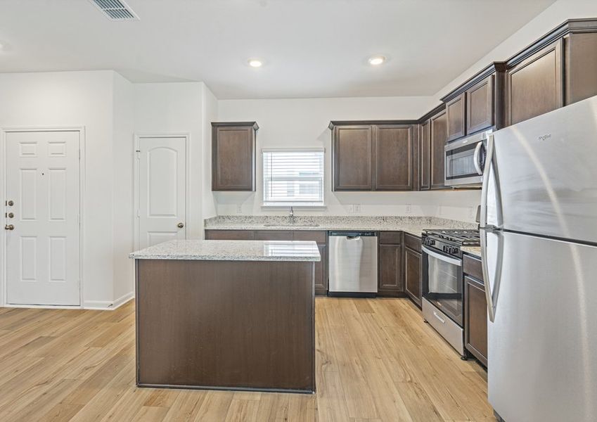 Upgraded kitchen with an island and granite countertops. Upgraded kitchen with an island and granite countertops.