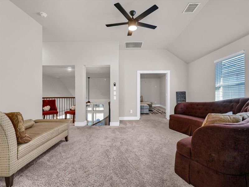 Carpeted living room with lofted ceiling and ceiling fan Carpeted living room with lofted ceiling and ceiling fan