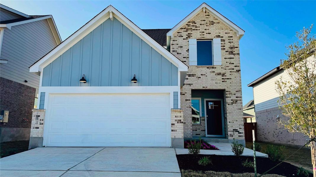 View of front of home featuring board and batten siding, driveway, brick siding, and a garage View of front of home featuring board and batten siding, driveway, brick siding, and a garage