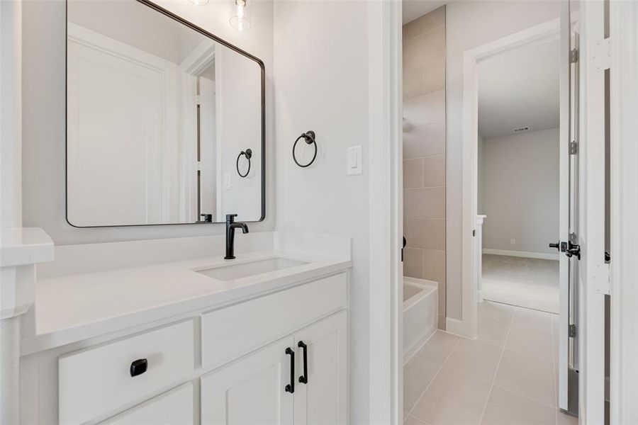 Bathroom featuring vanity, light tile patterned floors, and bathtub / shower combination