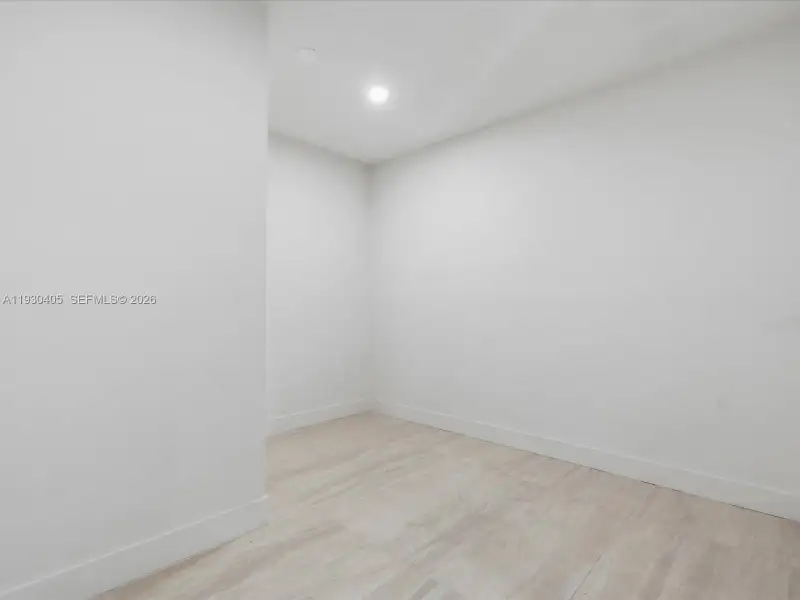 Neutral-toned interior space featuring light wood-finish flooring and recessed lighting Neutral-toned interior space featuring light wood-finish flooring and recessed lighting