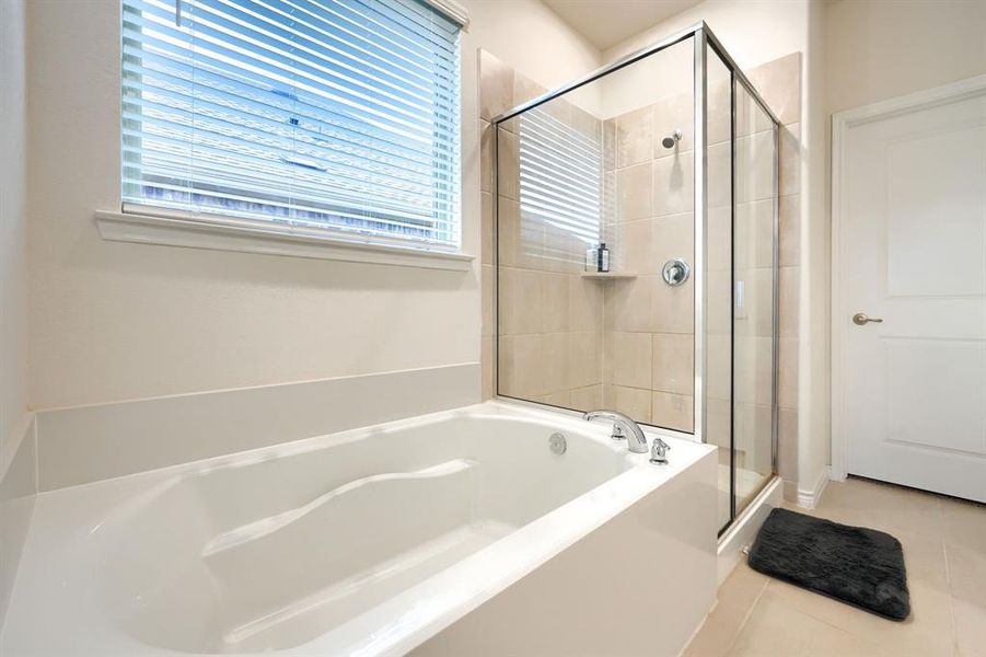 Bathroom with a bath, light tile patterned floors, and a shower stall Bathroom with a bath, light tile patterned floors, and a shower stall