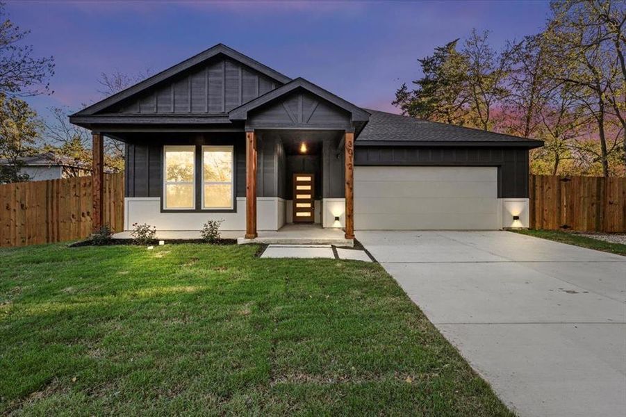 View of front of house with a yard and a garage