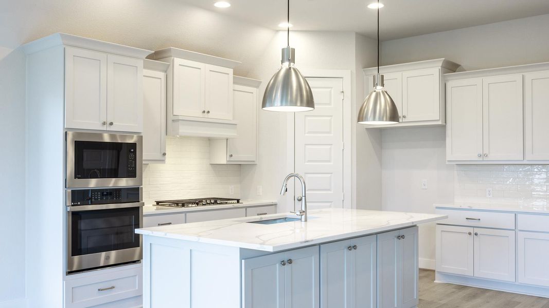 Kitchen with tasteful backsplash, appliances with stainless steel finishes, white cabinets, light wood-style floors, and recessed lighting Kitchen with tasteful backsplash, appliances with stainless steel finishes, white cabinets, light wood-style floors, and recessed lighting