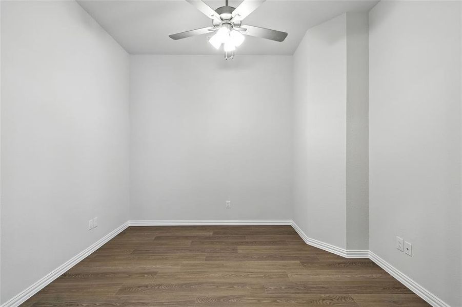 Empty room featuring dark wood-type flooring and ceiling fan