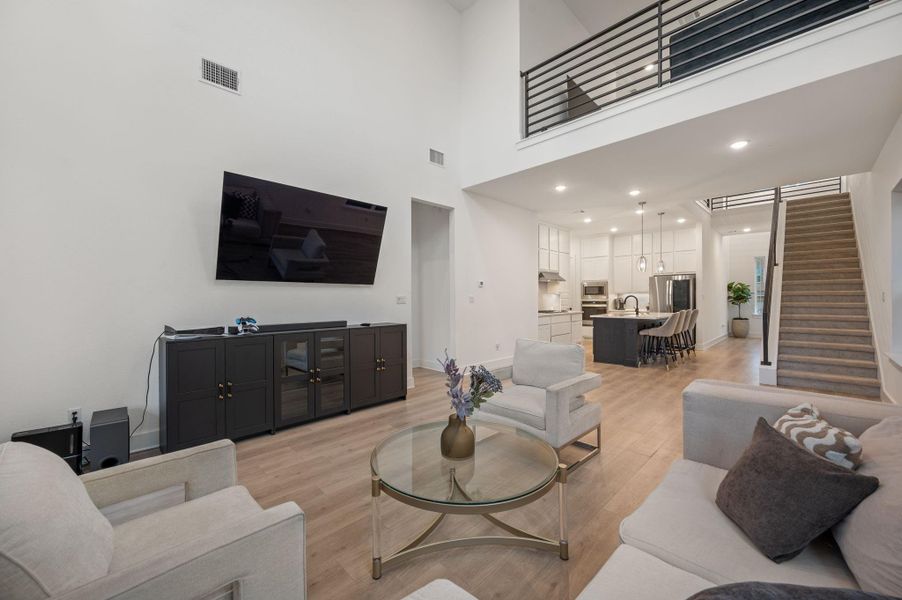 Living room with high ceilings and second story living area open to below