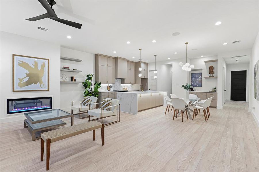 Living area with visible vents, ceiling fan, light wood-type flooring, recessed lighting, and a glass covered fireplace