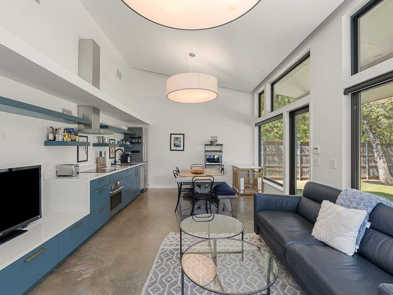 Living room with concrete flooring and a high ceiling