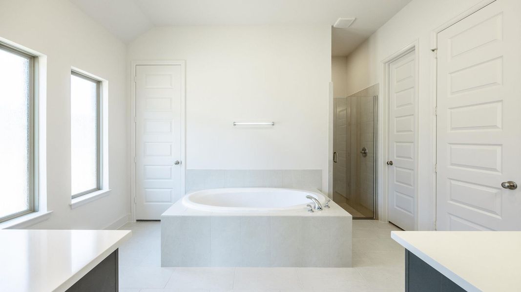 Full bathroom featuring vanity, a bath, a shower stall, and tile patterned floors Full bathroom featuring vanity, a bath, a shower stall, and tile patterned floors