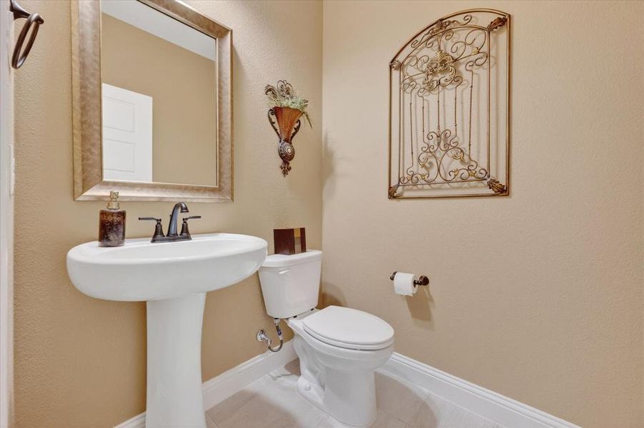 Half bathroom with baseboards and tile patterned floors Half bathroom with baseboards and tile patterned floors