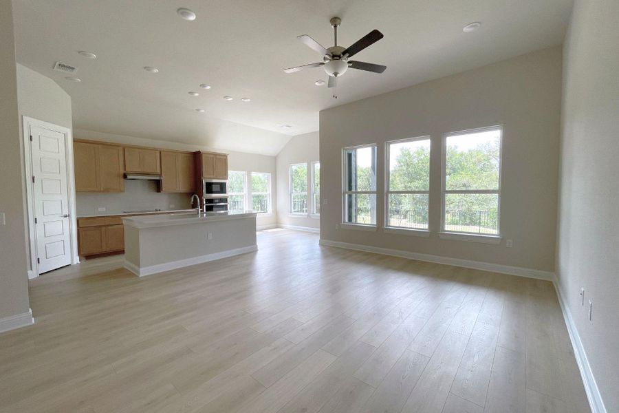 An open-concept great room and kitchen flow seamlessly, highlighted by soaring ceilings and ample natural light.