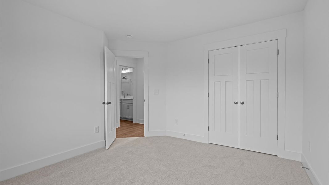 Accomplished design shines in this carpeted bedroom with a functional walk-in closet