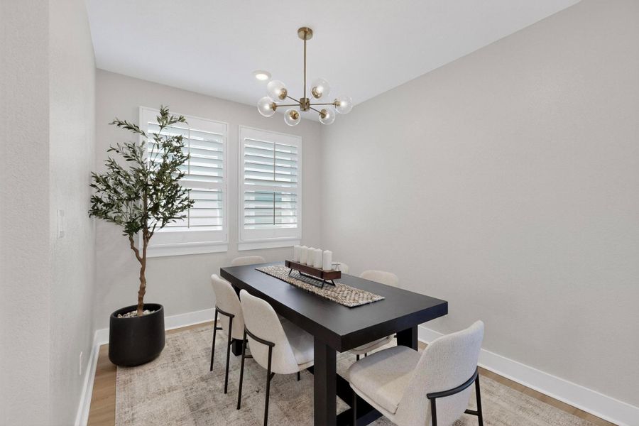 Dining room with light wood finished floors and a chandelier