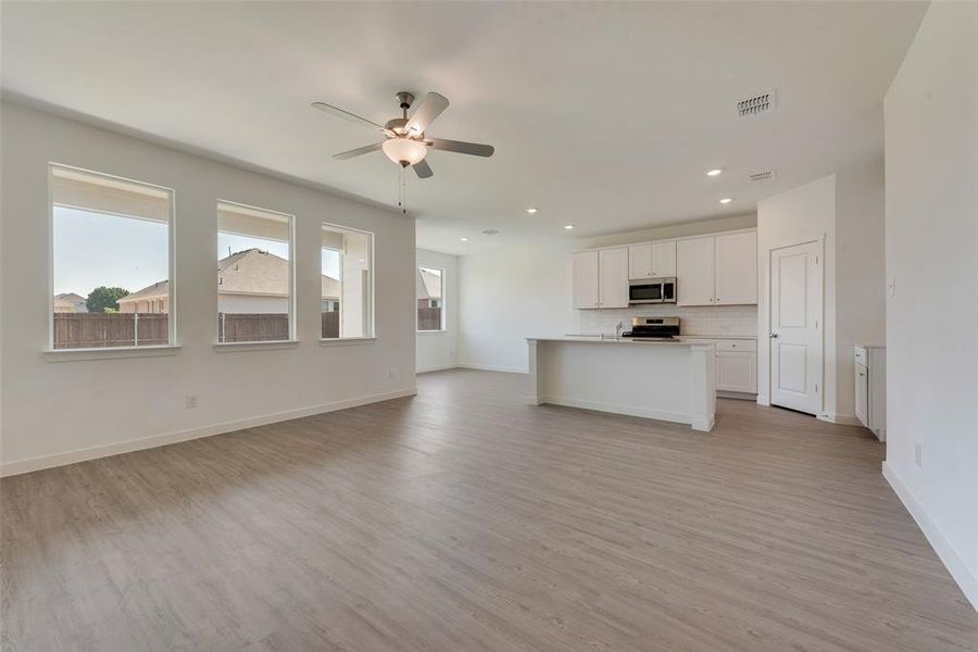 Unfurnished living room featuring light hardwood / wood-style flooring and ceiling fan