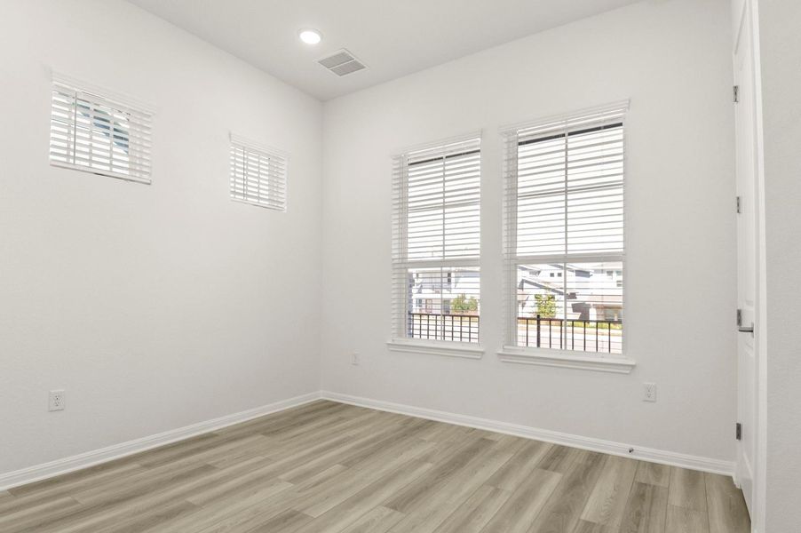 Empty room with light wood-type flooring and recessed lighting