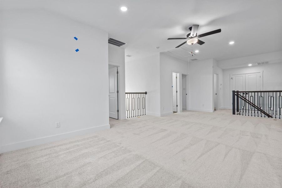 Empty room featuring ceiling fan and light colored carpet