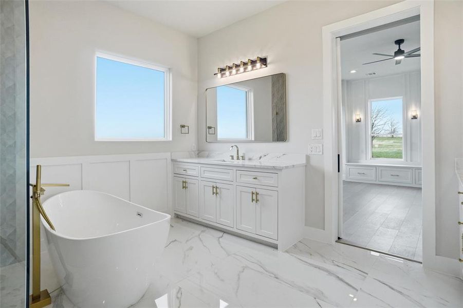 Spacious primary bathroom with separate vanities, freestanding soaking tub, and walk-in shower.