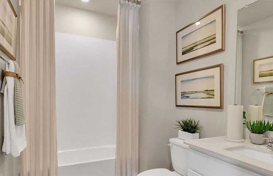 Bathroom featuring vanity, toilet, and shower / bath combo with shower curtain Bathroom featuring vanity, toilet, and shower / bath combo with shower curtain