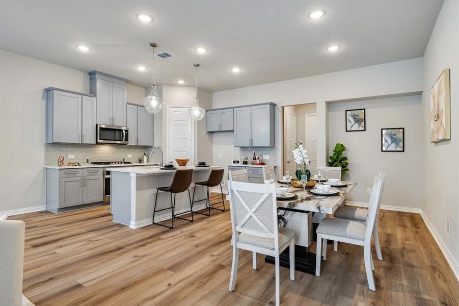 Dining area with light hardwood / wood-style floors and sink