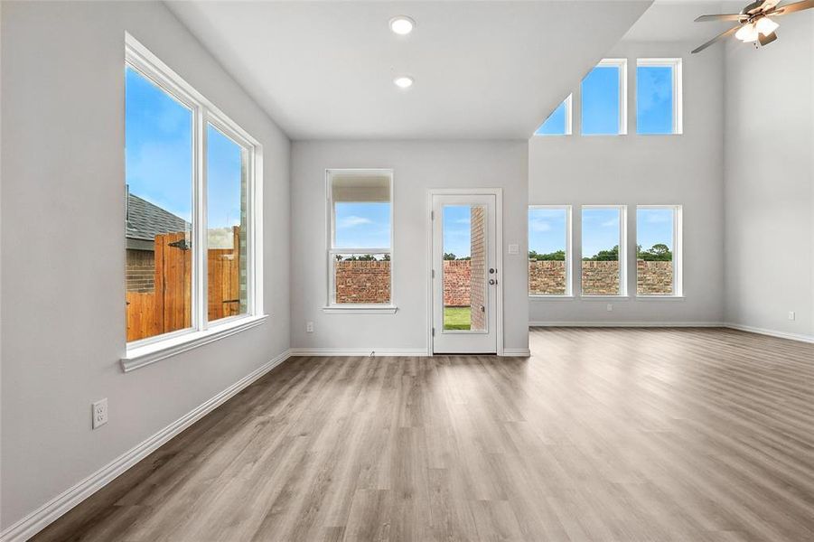 Unfurnished living room featuring healthy amount of natural light, wood finished floors, recessed lighting, and a ceiling fan Unfurnished living room featuring healthy amount of natural light, wood finished floors, recessed lighting, and a ceiling fan