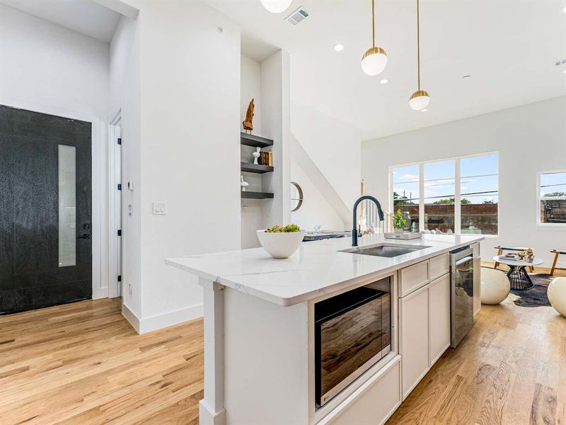 Stainless steel appliances including gas stove, microwave & refrigerator.