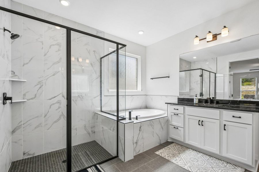 Modern primary bath boasts a large walk-in shower and separate soaking tub for ultimate relaxation.