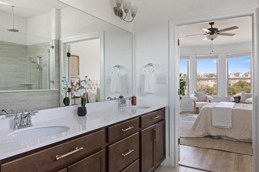 Full bathroom featuring ensuite bathroom, double vanity, a ceiling fan, a tile shower, and light wood-style flooring Full bathroom featuring ensuite bathroom, double vanity, a ceiling fan, a tile shower, and light wood-style flooring