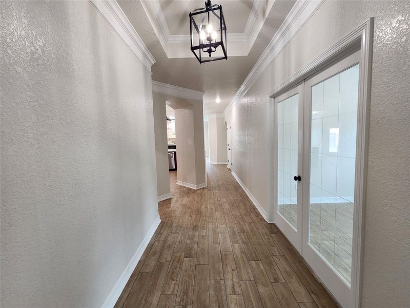 Step into this luminous corridor showcasing elegant wood-look flooring and stylish French doors. Step into this luminous corridor showcasing elegant wood-look flooring and stylish French doors.