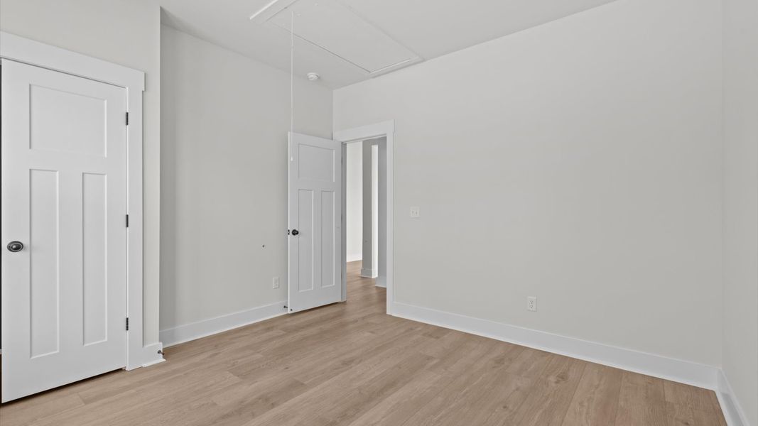 Thoughtfully designed secondary bedrooms featuring hardwood flooring and tasteful detail