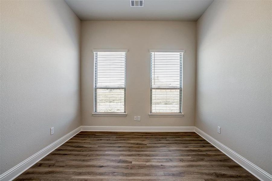 Empty room featuring dark hardwood / wood-style flooring