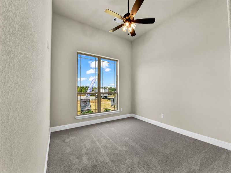 Carpeted empty room with ceiling fan