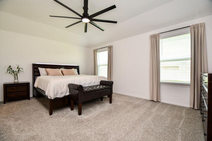 This spacious primary bedroom has two windows, modern ceiling fan, and plush carpet making this your comfortable retreat.