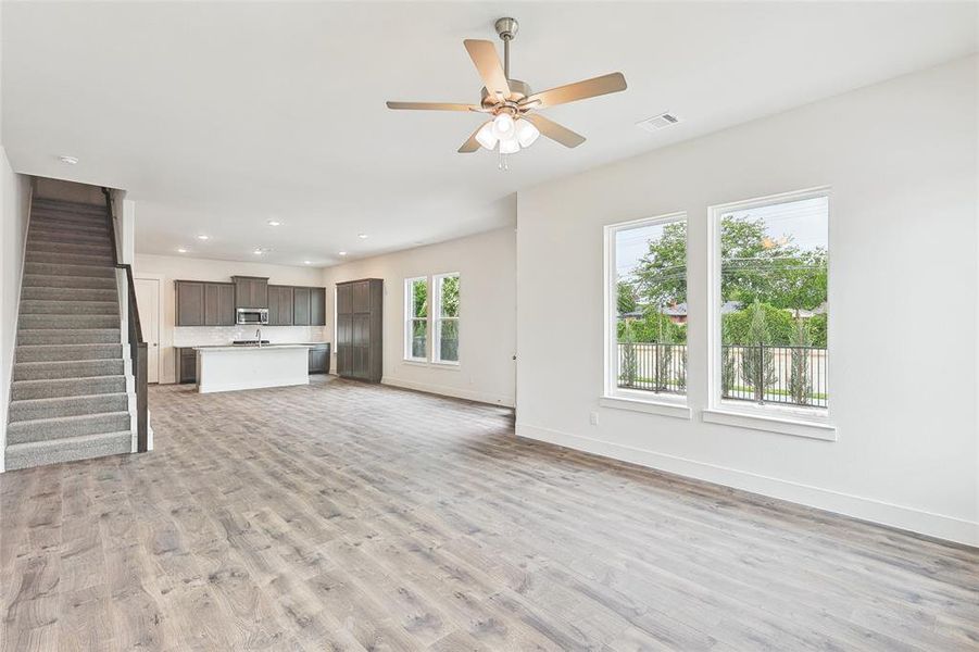 Unfurnished living room with ceiling fan and light hardwood / wood-style flooring