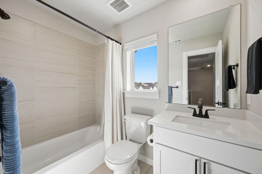 Tiled shower walls and a sleek single-sink vanity define this updated bathroom space. Tiled shower walls and a sleek single-sink vanity define this updated bathroom space.