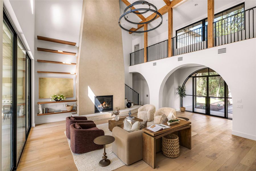 Towering ceilings and exposed timber beams frame a magnificent plaster fireplace wall.