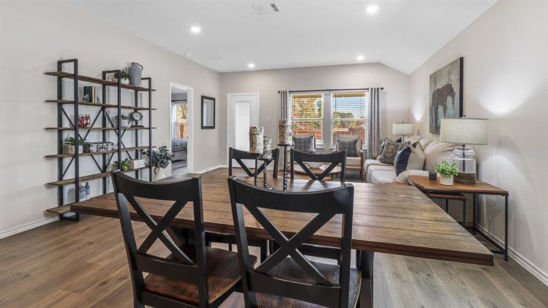 Dining room with recessed lighting, wood finished floors, and lofted ceiling