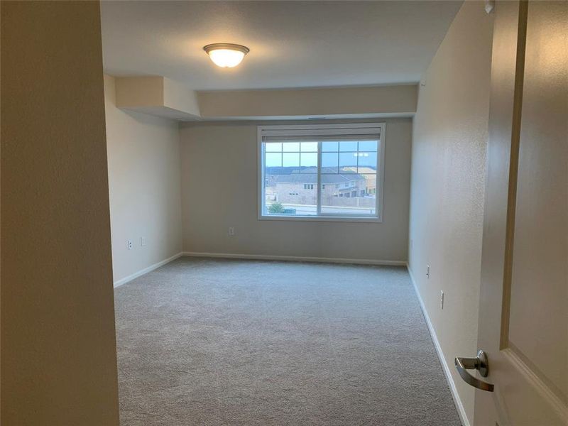 Empty room featuring light colored carpet and baseboards