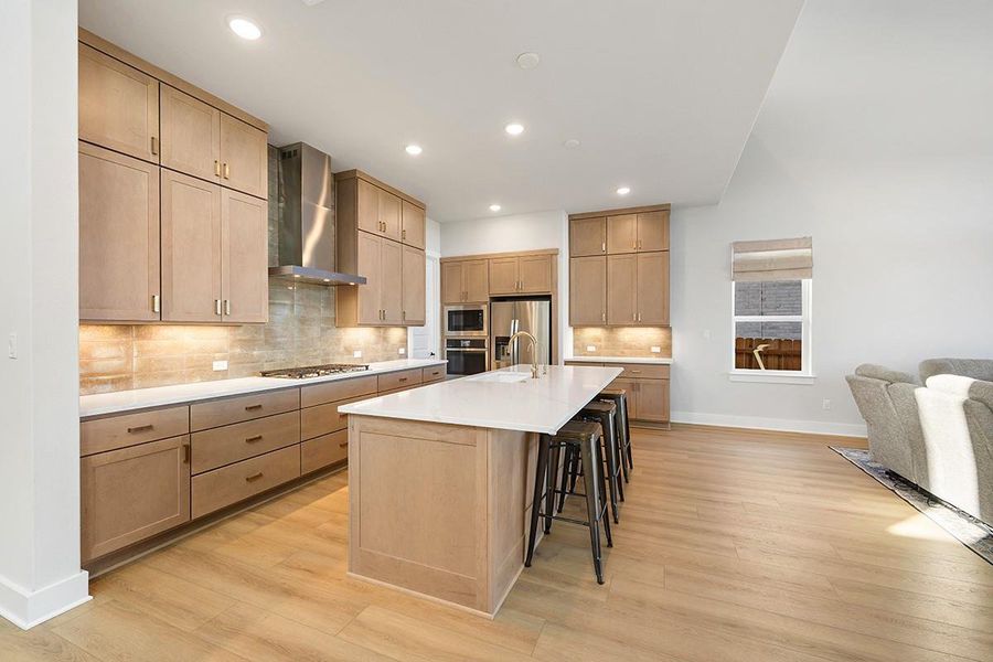 Sleek wood cabinetry and a generous center island define this airy open-concept kitchen space.