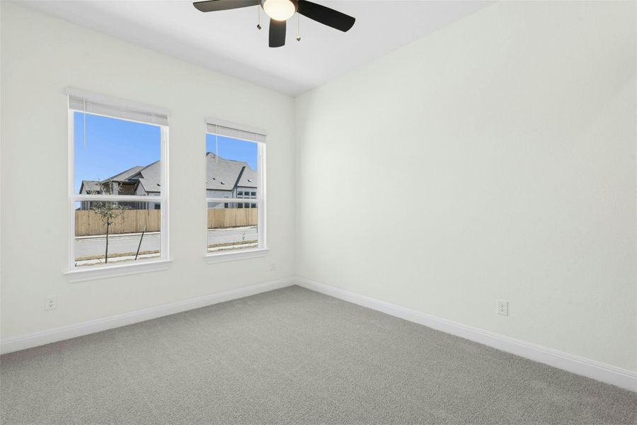 Empty room featuring carpet flooring and a ceiling fan