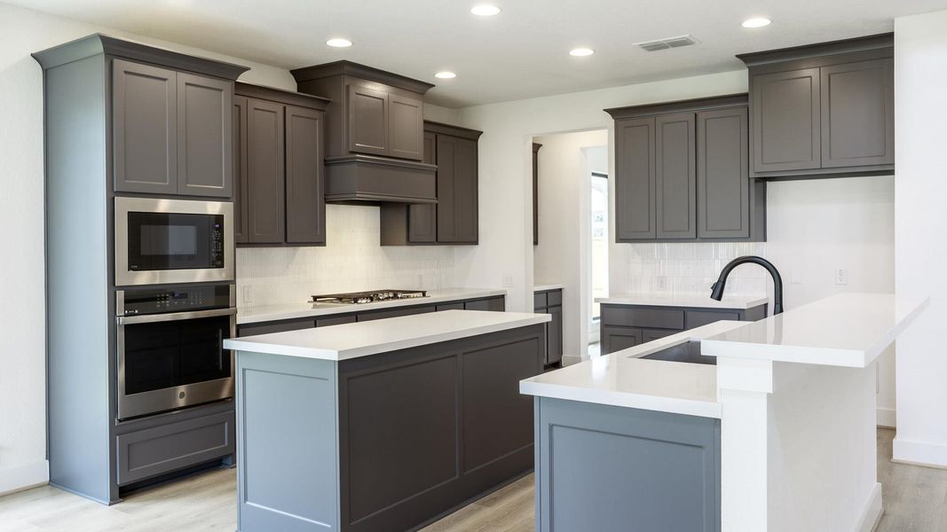 Kitchen featuring tasteful backsplash, appliances with stainless steel finishes, recessed lighting, light stone counters, and gray cabinets