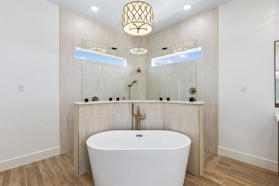 Bathroom featuring tile patterned flooring, tile walls, a healthy amount of sunlight, and separate shower and tub