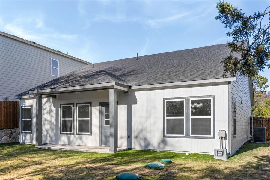 Rear view of property featuring a patio area and roof with shingles