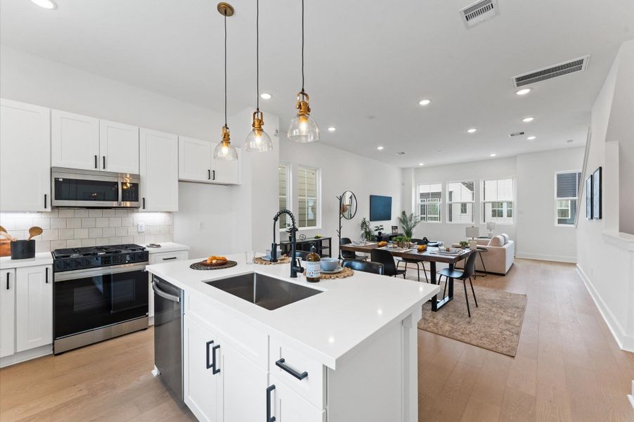 At the heart of this open-concept kitchen lies a stunning oversized island, offering generous prep space, sleek quartz countertops, and seating for up to six. Whether you're hosting a dinner party or enjoying a casual breakfast, this island is the perfect gathering spot. Pendant lighting adds a touch of elegance, while built-in storage and a deep farmhouse sink make it as functional as it is beautiful