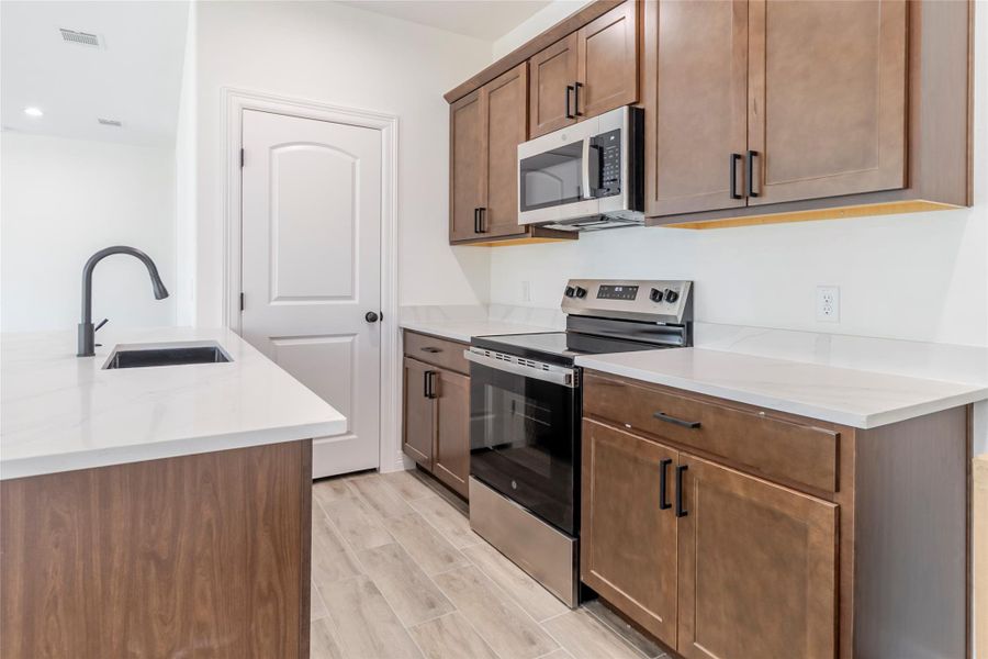 Quartz counters run alongside the SS appliances, with plenty of prep and storage space. Quartz counters run alongside the SS appliances, with plenty of prep and storage space.