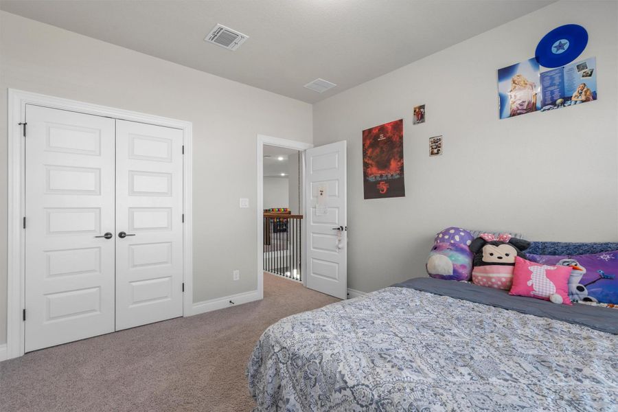 Smooth carpeting and recessed paneled doors define this comfortable sleeping space.