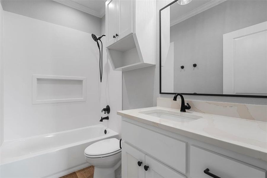 Bathroom with bathing tub / shower combination, vanity, crown molding, and wood finished floors Bathroom with bathing tub / shower combination, vanity, crown molding, and wood finished floors