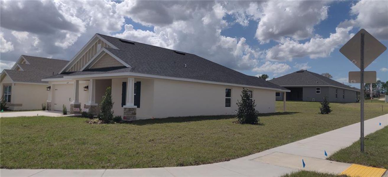 Front exterior of a new home in Sunset Landing, Spring Hill, FL, highlighting curb appeal (Image 2).